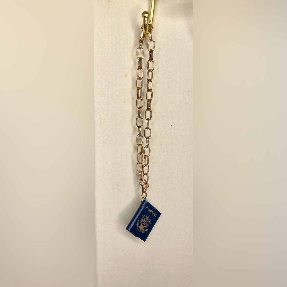 Gold chain bracelet with miniature passport charm